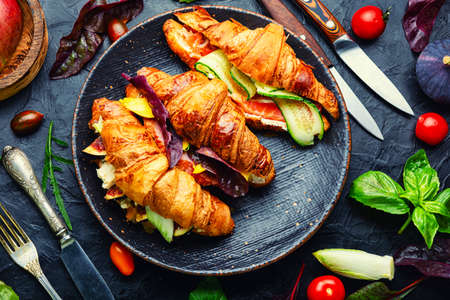 Fresh croissants with salted filling.Croissants with trout, meat bacon, vegetables and fruitsの写真素材
