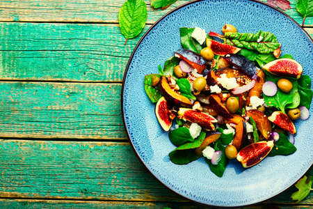 Autumn salad with plums,figs and olives.Summer salad of fruits and nuts.Copy spaceの写真素材