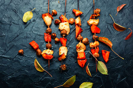 Meat kebab roasted with pumpkin and mushrooms.Grilled chicken on bamboo skewersの写真素材