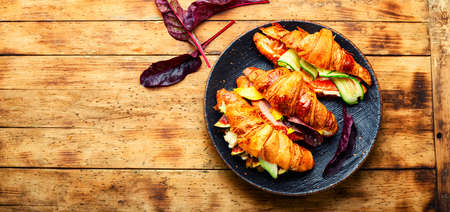 Croissants with salted filling.Croissants with salmon, bacon, figs and cucumber.Space for textの写真素材
