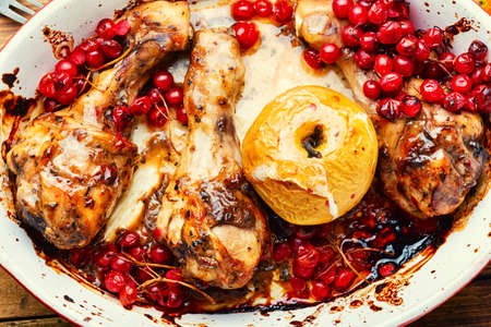 Delicious baked chicken legs with autumn berries.Chicken drumsticks roasted with viburnumの写真素材
