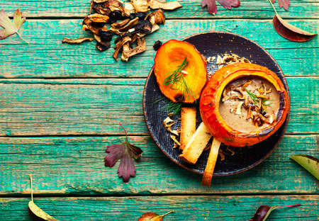 Homemade mushroom cream soup in pumpkin.Traditional lenten autumn soup.Copy spaceの写真素材