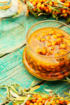 Healthy sea buckthorn jam. Homemade berry jam on wooden surface