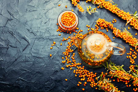 Tea with sea buckthorn. Delicious fresh tea from autumn berries in glass teapot.Copy spaceの写真素材