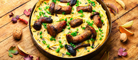 Autumn pie with forest mushrooms on rustic wooden tableの写真素材
