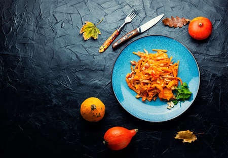 Warm autumn salad of roasted pumpkins and pork ears.Space for textの写真素材