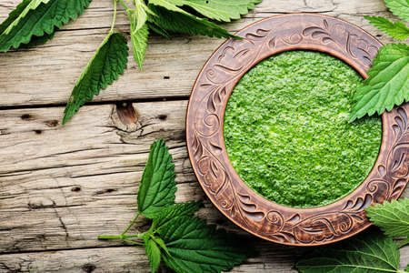Homemade soup with fresh nettle leaves. Creamy herbal soupon wooden table. Healthy food.の写真素材