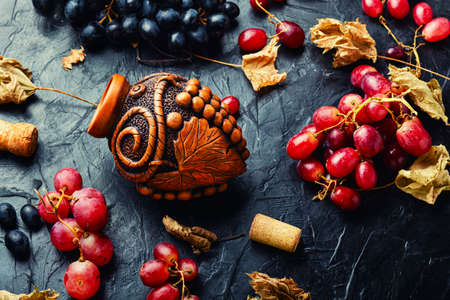 Young grape wine in a vessel. Beautiful wine flask with autumn grape wineの写真素材