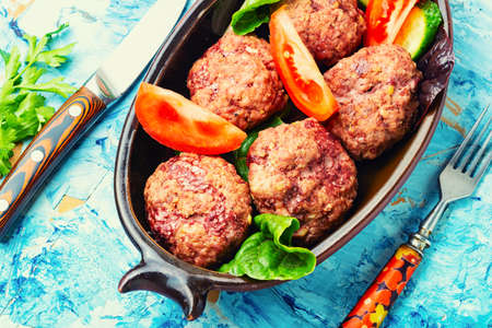 Delicious dietary veal meatballs. Steam rissole and sliced vegetables