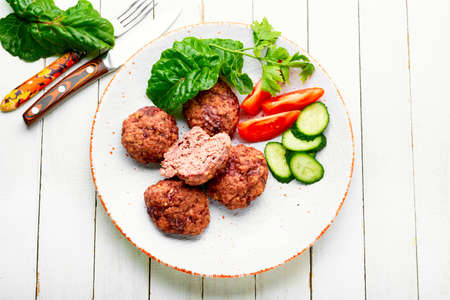 Delicious dietary veal meatballs. Steam cutlets and sliced vegetables