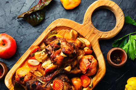 Pork knuckle or shank grilled with apples on cutting boardの写真素材