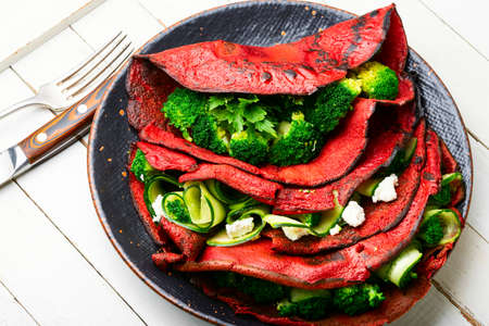 Colorful beetroot pancakes with broccoli and cucumber.の写真素材