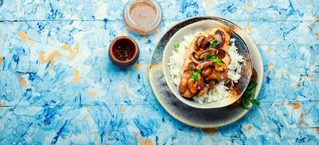 Chicken meat with mushroom sauce on a rice pad. Stewed meat with Sicilian marsala sauce. Copy spaceの写真素材