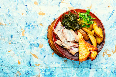 Pickled herring fish with roasted potatoes.Copy space