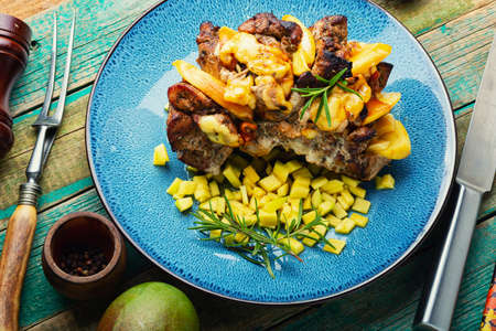 Appetizing pork meat baked with mango and cheeseの写真素材