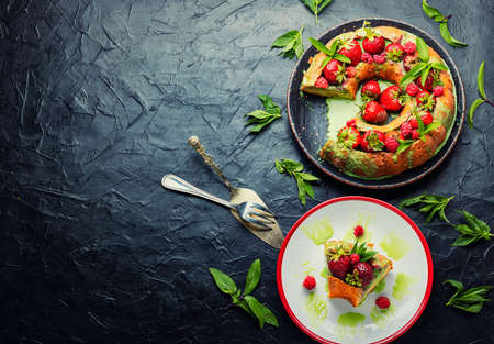 Appetizing pie with summer berries. Homemade cake with raspberries and strawberries. Space for text
