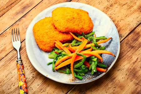 Appetizing chicken cutlet with a garnish from asparagus beans and carrotsの写真素材