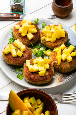 Vegan food, quinoa cutlet garnished with mango. Baked vegetarian burgerの写真素材