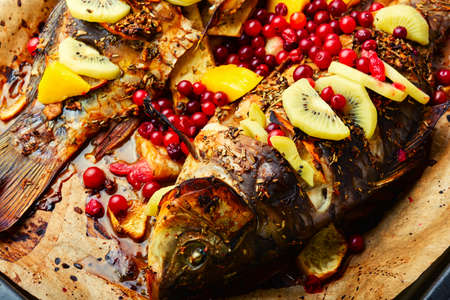Roasted river carp with fruits, berries and spices.の写真素材