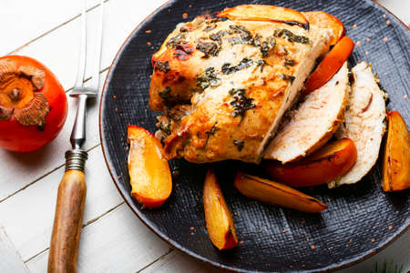 Aromatic chicken breast roasted with persimmon. Chicken meat baked with fruit.の写真素材