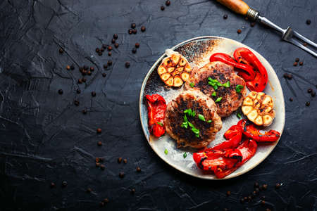 Fried beef steak with minced meat and garnish of roasted bell pepper and garlic. Copy spaceの写真素材
