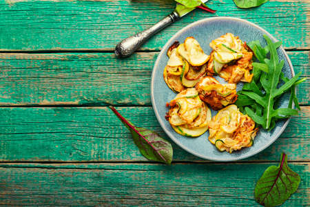Fried zucchini and fresh herbs on the plate. Space for textの写真素材