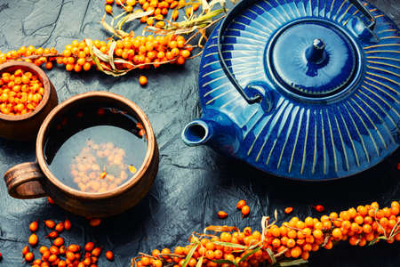 Healing tea with sea buckthorn. Delicious fresh tea from autumn berries.の写真素材