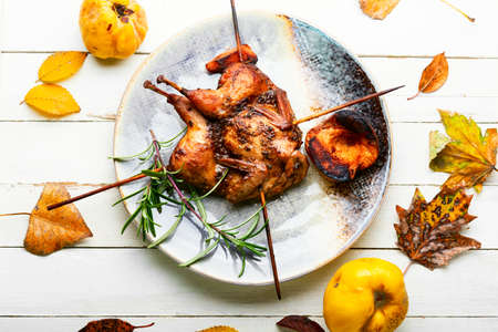 Shish kebab of quail and autumn quince on wooden skewersの写真素材