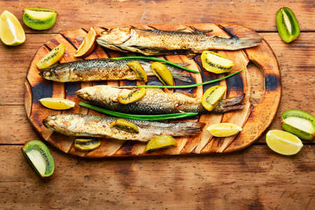 Tasty roast pelengas, fish with kiwi and lime.の写真素材