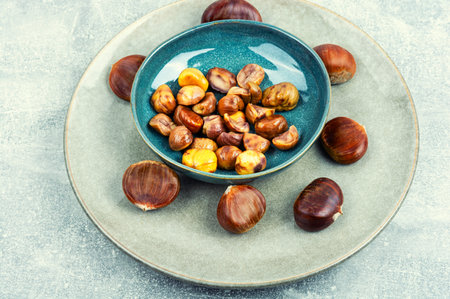 Roasted peeled chestnuts on the plate. Delicious treat: roasted chestnuts.の写真素材