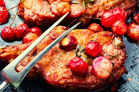 Two cooked steaks in a cherry marinade. Grilled meat with berry sauce. Close upの写真素材