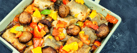 Roasted hake fish with orange, tomato and mushrooms.