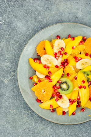 Salad of mango, citrus, banana and berries in a bowl. Healthy fresh fruit saladの写真素材