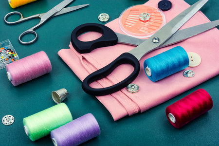 Home sewing kit, scissors, needles, color threads and buttons.