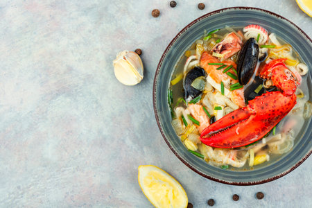 Seafood soup with lobster, mussels, shrimps and fish. Soup in ceramic bowl. Tom yum. Copy spaceの写真素材