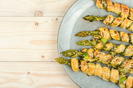 Green asparagus baked in dough with pesto sauce on a wooden rustic table. Copy space.の写真素材