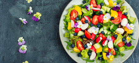 Spring colorful salad with vegetable and edible flowers. Healthy food. Copy space.の写真素材