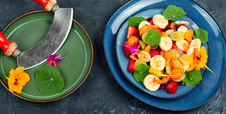 Vitamin fruit salad with banana, strawberries, grapes and nasturtiumの写真素材