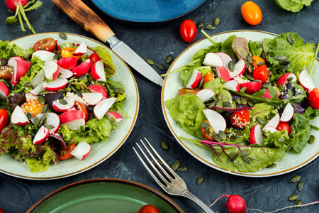 Salad with tomatoes and radishes, greens, tomato and sesame.の写真素材