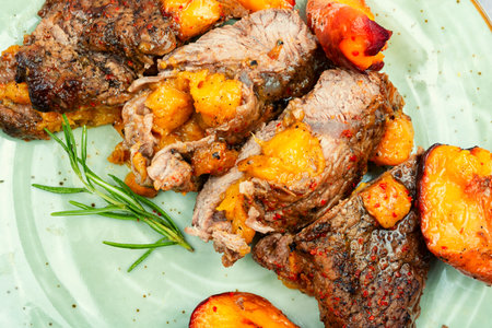 Succulent beef steak with peach in fruit marinade. Close-up.の写真素材