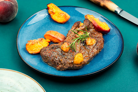 Diet baked veal steak with peachの写真素材