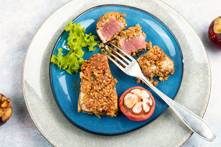 Plate of steak of baked tuna in a nut panic with mangosteens. Flat lay.の写真素材
