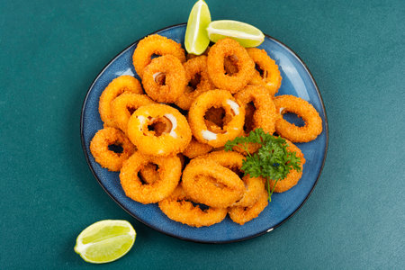 Baked breaded calamari rings served with limeの写真素材