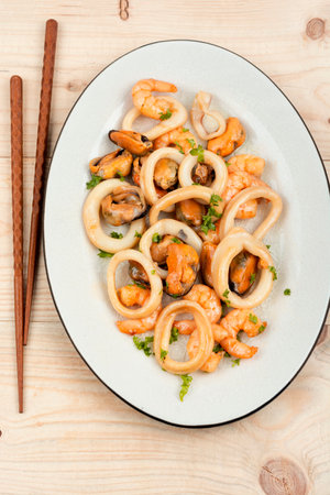 Roasted mussels, squid and shrimp and chopsticksの写真素材