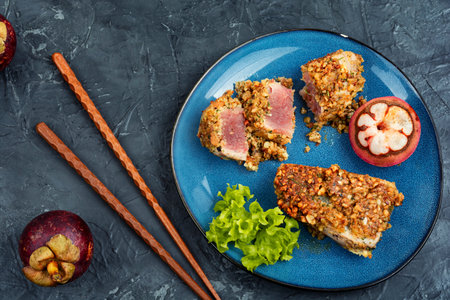 Steak of baked tuna in a nut with a mangosteens. Diet food. Flat lay.の写真素材