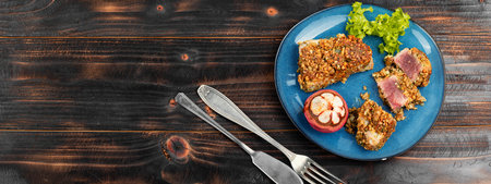 Steak of baked tuna in a nut panic with a mangosteens. Space for text.の写真素材