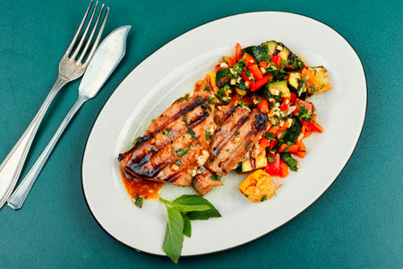 Grilled tuna steak served with vegetables salad on a plateの写真素材