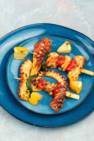 Tasty seafood octopus tentacles skewers. Barbecue octopus on blue plate.