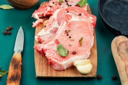 Raw pork steak, meat with seasoning on a wooden board. Entrecote.の写真素材