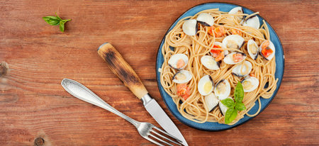 Seafood pasta with clams vongole and spaghetti on rustic wooden table background. Space for textの写真素材